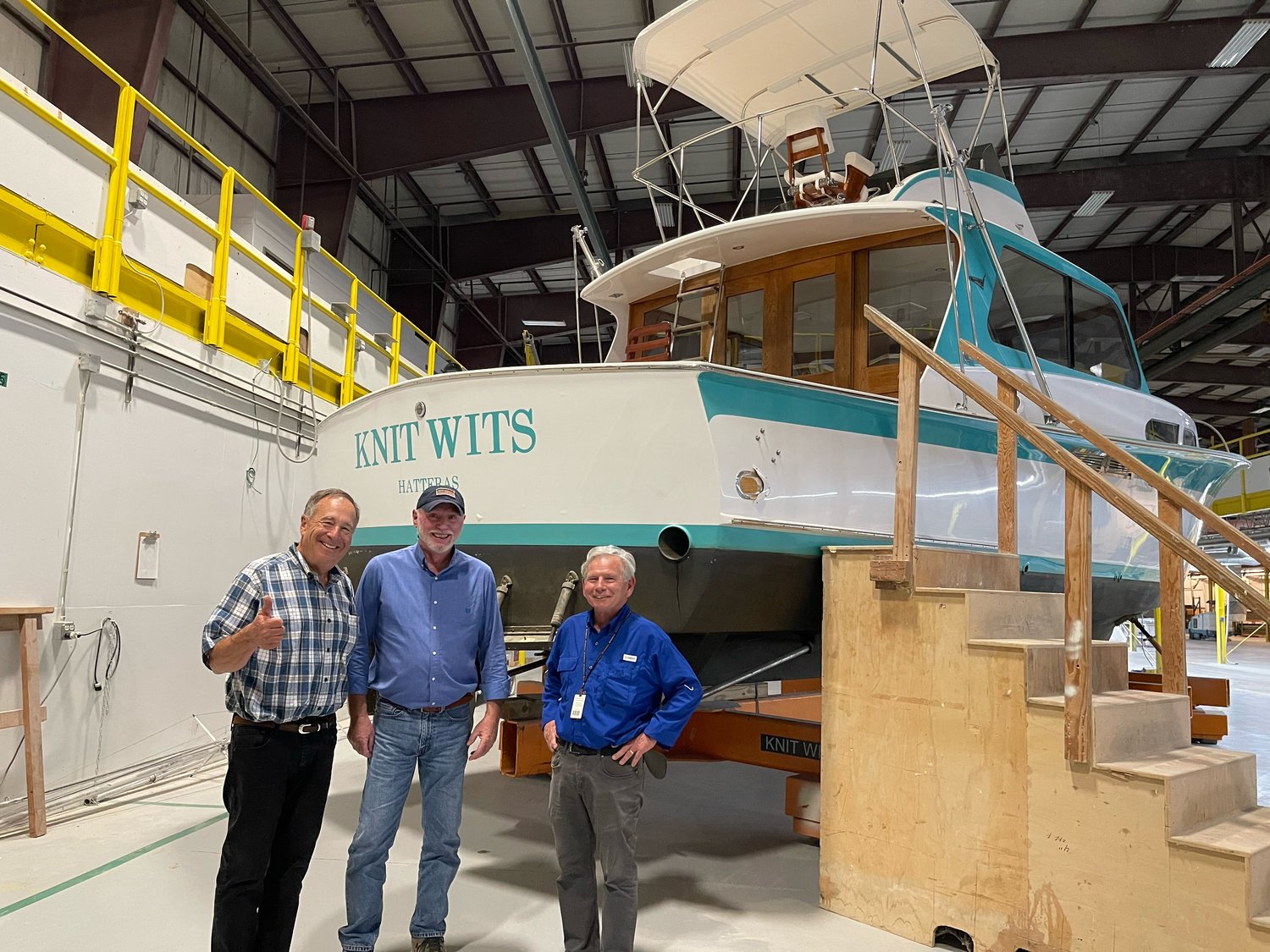 Bass Pro and White River founder Johnny Morris, at left, stands in front of the first Hatteras sportfishing boat ever built with company veterans Alden Harris and Bob Arthur.